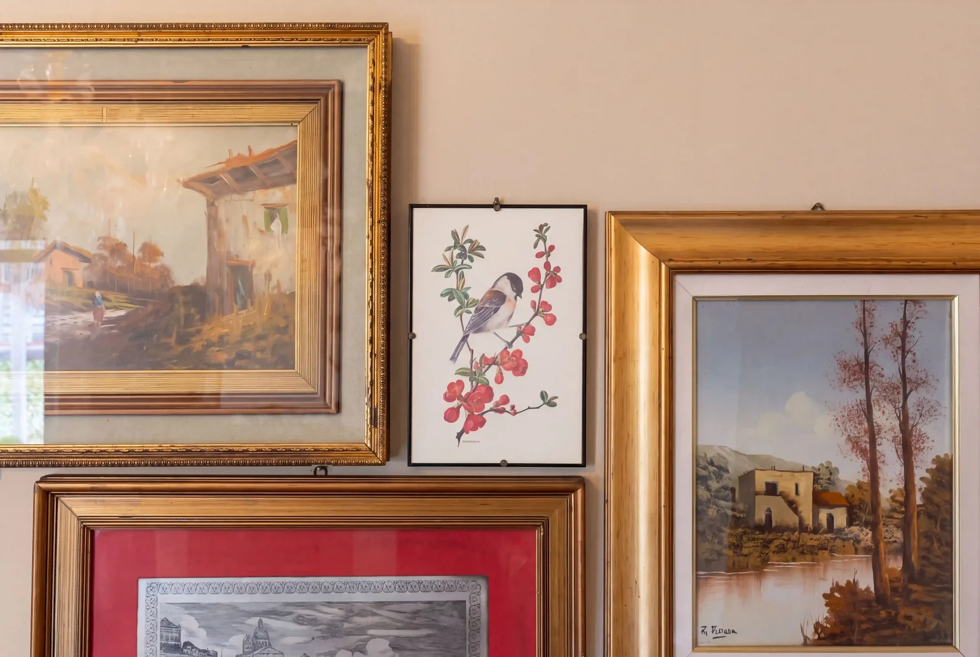 Composizione di quadri con paesaggi e fiori in cornici dorate e in legno sulle pareti della casa