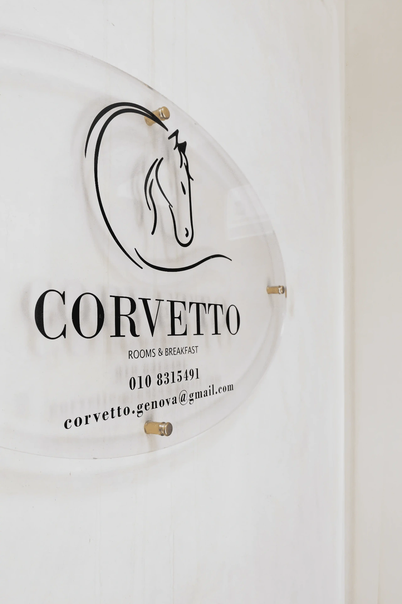 Targa di Corvetto Rooms & Breakfast con il logo della testa di cavallo sulla parete chiara