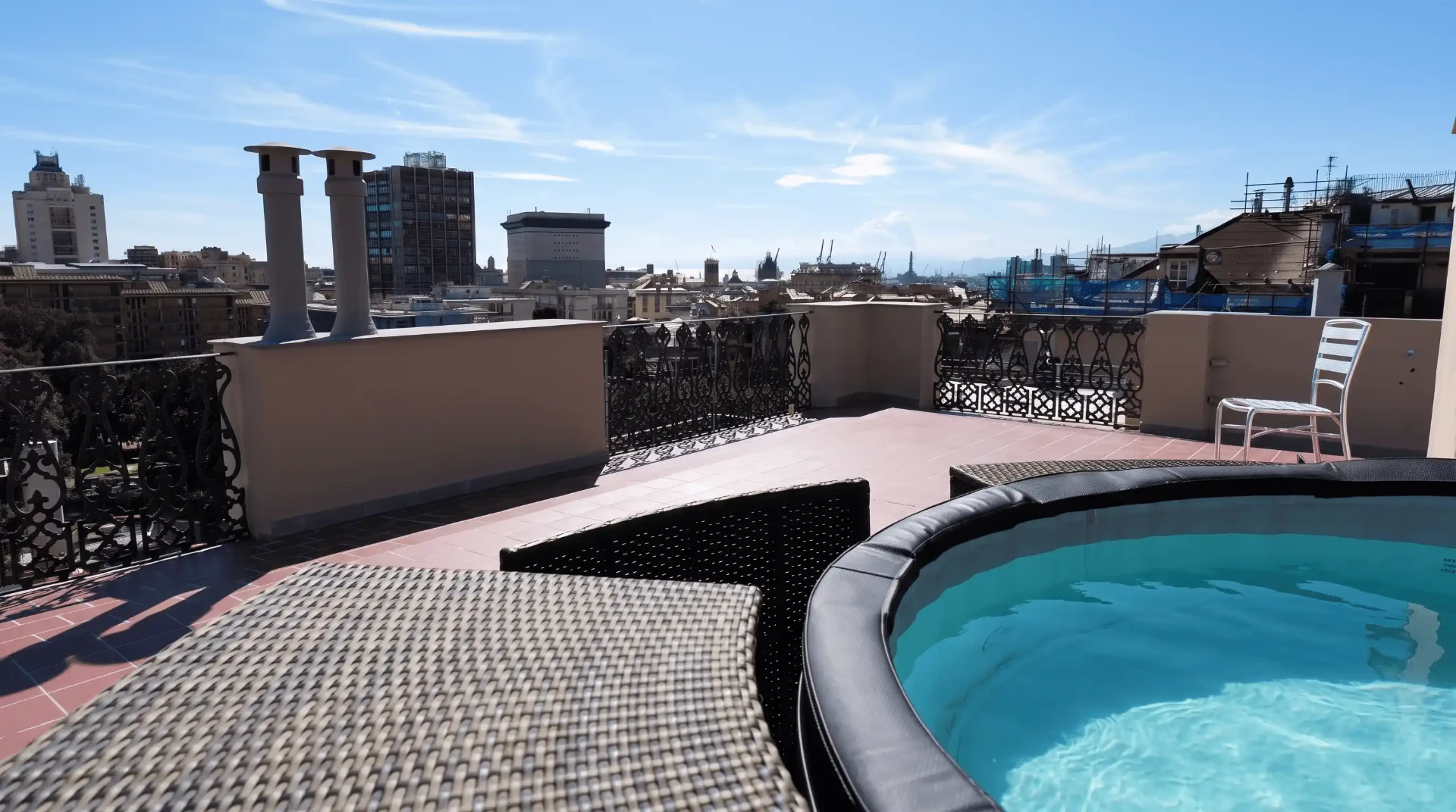 Terrazzino privato della Suite con vasca della mini spa, ringhiera in ferro battuto e vista sui tetti di Genova